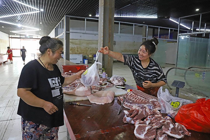 8月25日，涿州市新发地大石桥批发市场生鲜卖场，顾客在摊位前挑选猪肉。熊华明摄