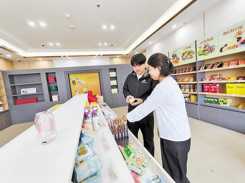 10月11日，雄安保税商品直购体验店工作人员（左）向消费者介绍保税商品。 本报见习记者 康晓博摄