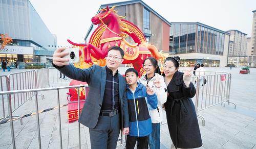 3月10日傍晚，雄安奥特莱斯北区南广场，巩文通一家四口打卡拍照。 本报见习记者 李 畅摄