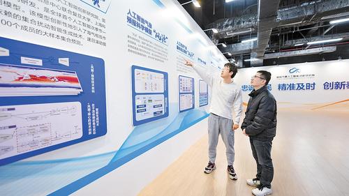 近日，在雄安气象人工智能创新研究院展示大厅，窦则胜（左）和工作人员正在探讨人工智能气象预报科学模型“风源”的迭代升级工作。本报记者 李 畅摄