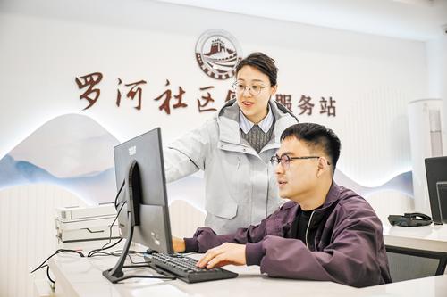 4月17日，李泽（左）与工作人员一起讨论社区治理方案。 本报记者 李东宇摄