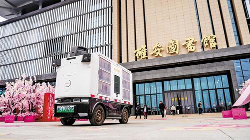日前，雄安图书馆无人智能送书车在运送书籍。