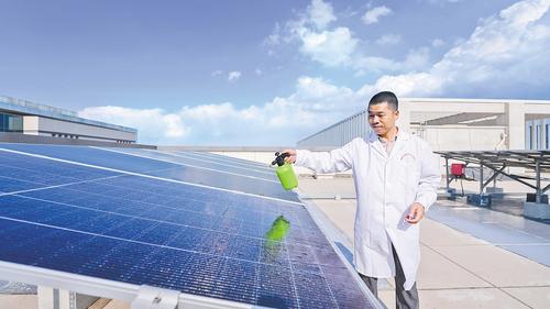 6月4日，雄安科创中心C座楼顶，雄安百城百润纳米科技有限公司首席技术官周明正在向光伏板喷洒太阳能光伏提效涂层材料。 本报记者 李 畅摄