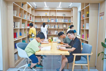 在雄安新区保障房社区,居民与子女在“四点半课堂”共同读书。