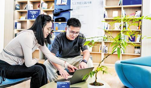 9月11日，雄安人工智能产业园OPC生态社区，杨宏伟（右）在社区的公共会客厅和客户对接业务。