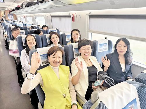 9月28日8时多，在首班复兴号G8854次列车上，旅客正在挥手示意。本报记者 吕若汐摄